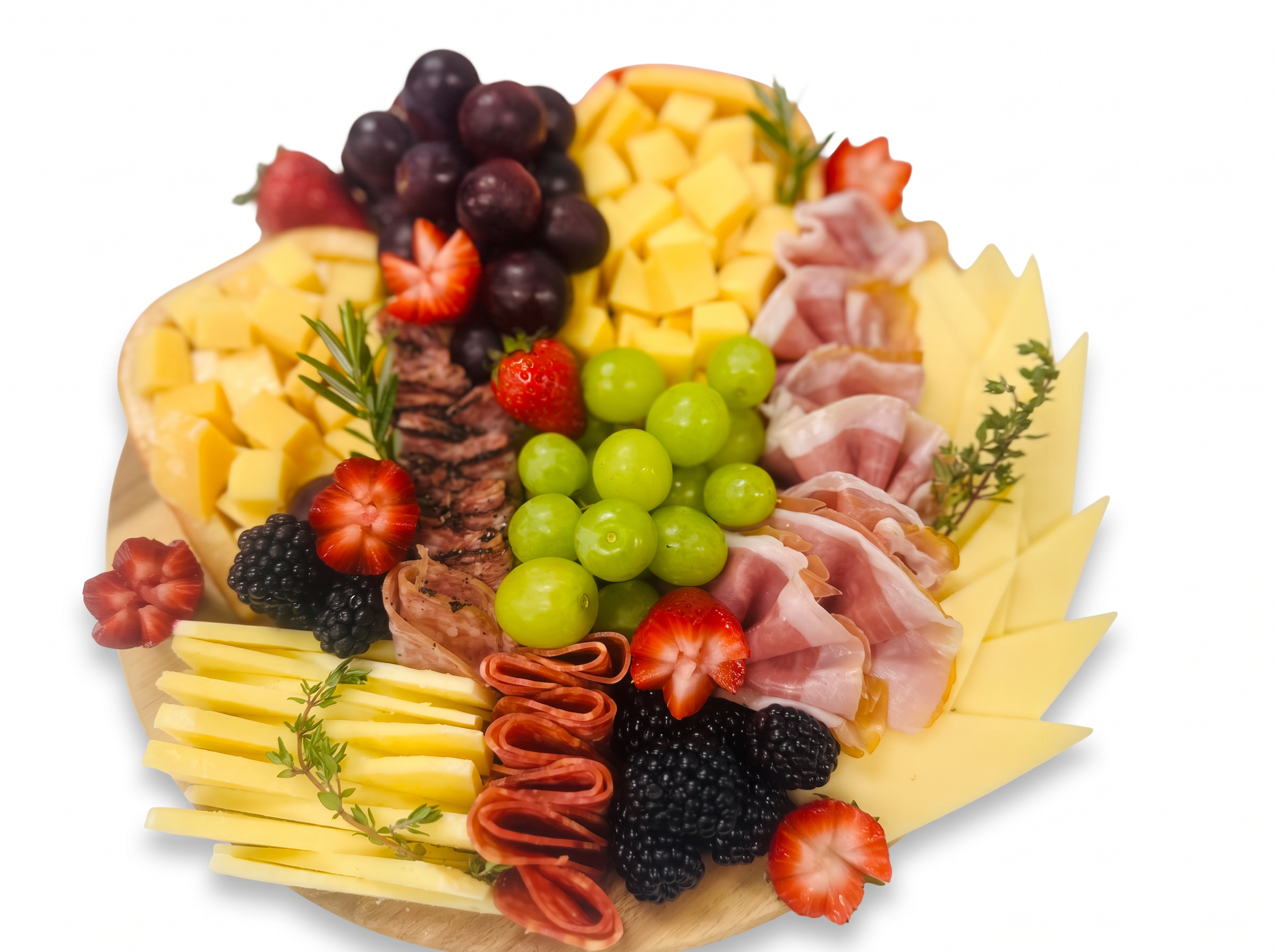 Round charcuterie board with grapes, cheeses, berries, and prosciutto
